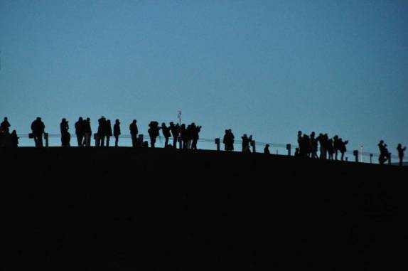 Uma multidão observa e fotografa a lua nascendo por detrás das nuvens, no topo do Mauna Kea, na Big island, no Hawaii